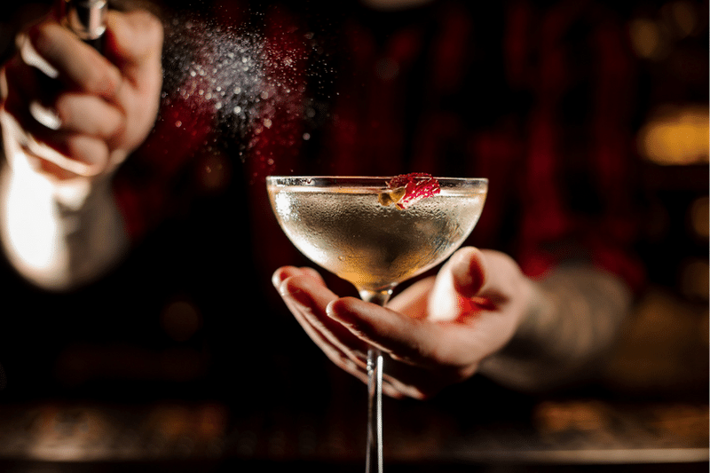 Mixologist spritzing a cocktail more wedding revenue