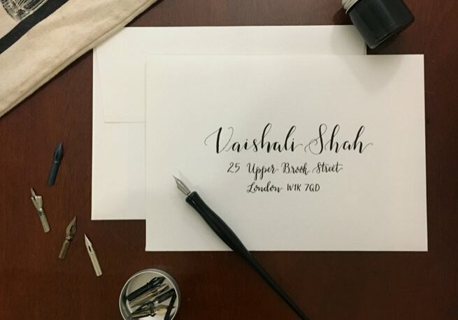 Black calligraphy writing on a white envelope with calligraphy pen | Kelly Chandler Consulting