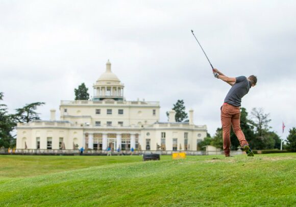 Man hitting a golf ball outside Stoke park gold club | Kelly Chandler Consulting